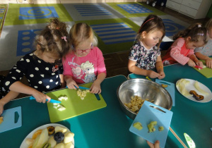 Dzieci kroją owoce do sałatki.